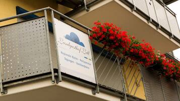 A building with a sign for "Landgasthof Bell" and a balcony with red flowers.
