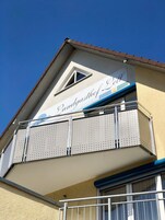 Un edificio con balcón que presenta barandillas de metal perforado y un cartel que dice "Landgasthof Cell".