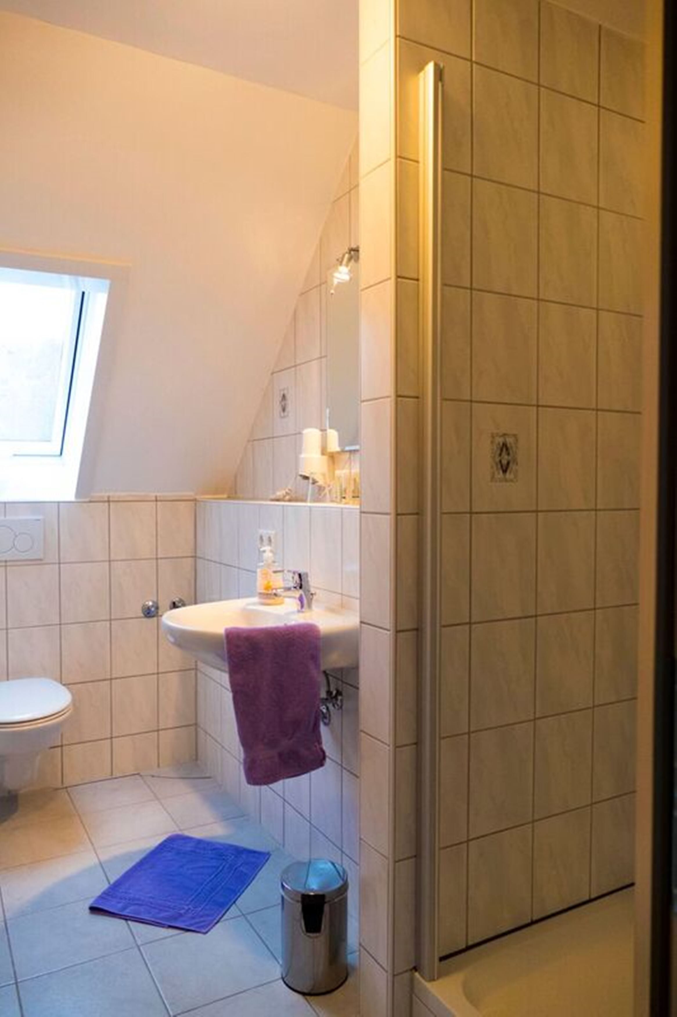 Une salle de bain comprenant des toilettes, un lavabo et un espace douche.