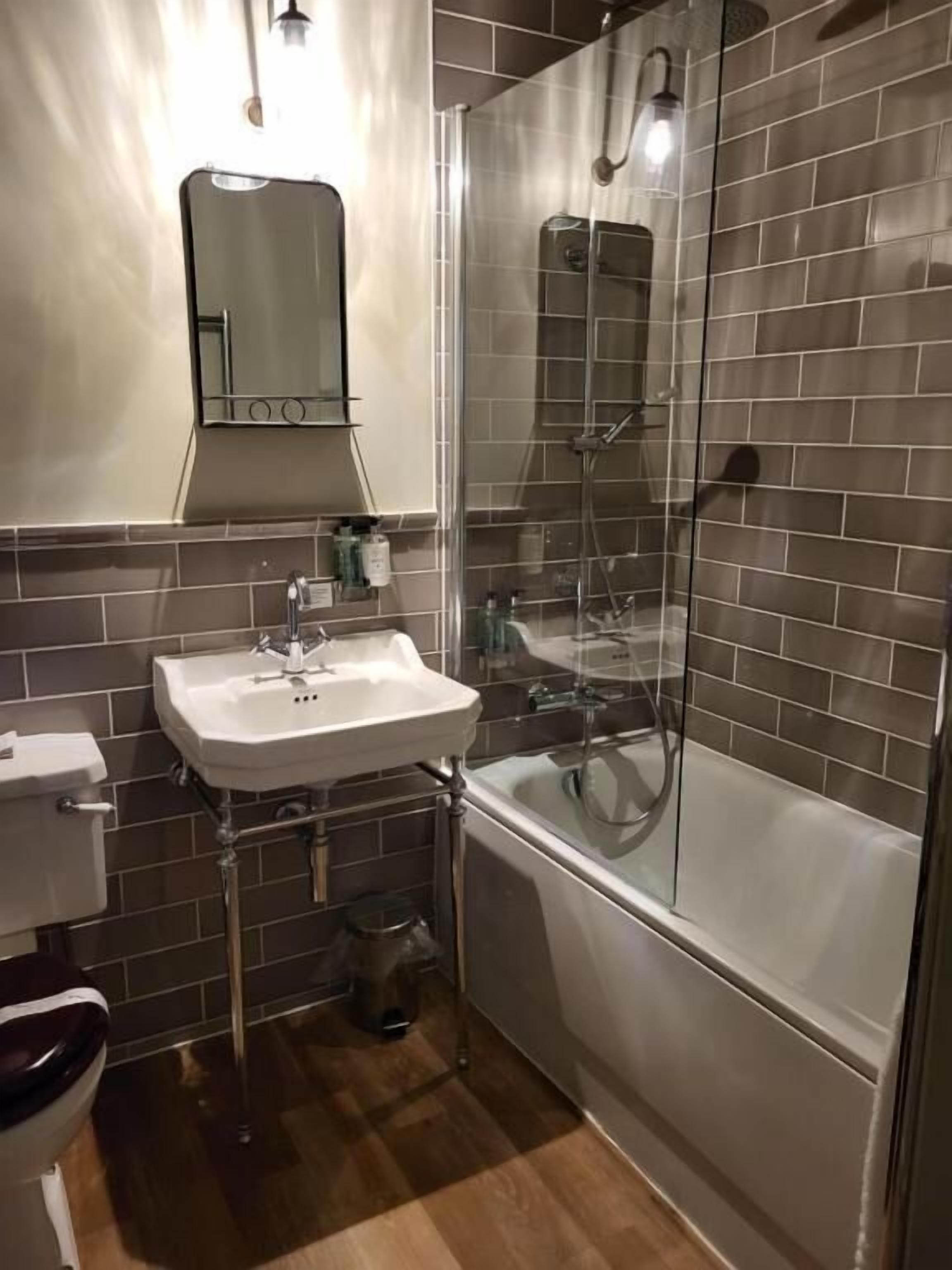 A bathroom with a sink, toilet, and shower.