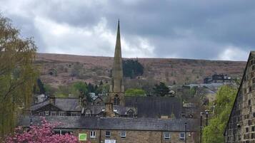 A town with a prominent church spire, a mix of residential and commercial buildings, and a parking area.