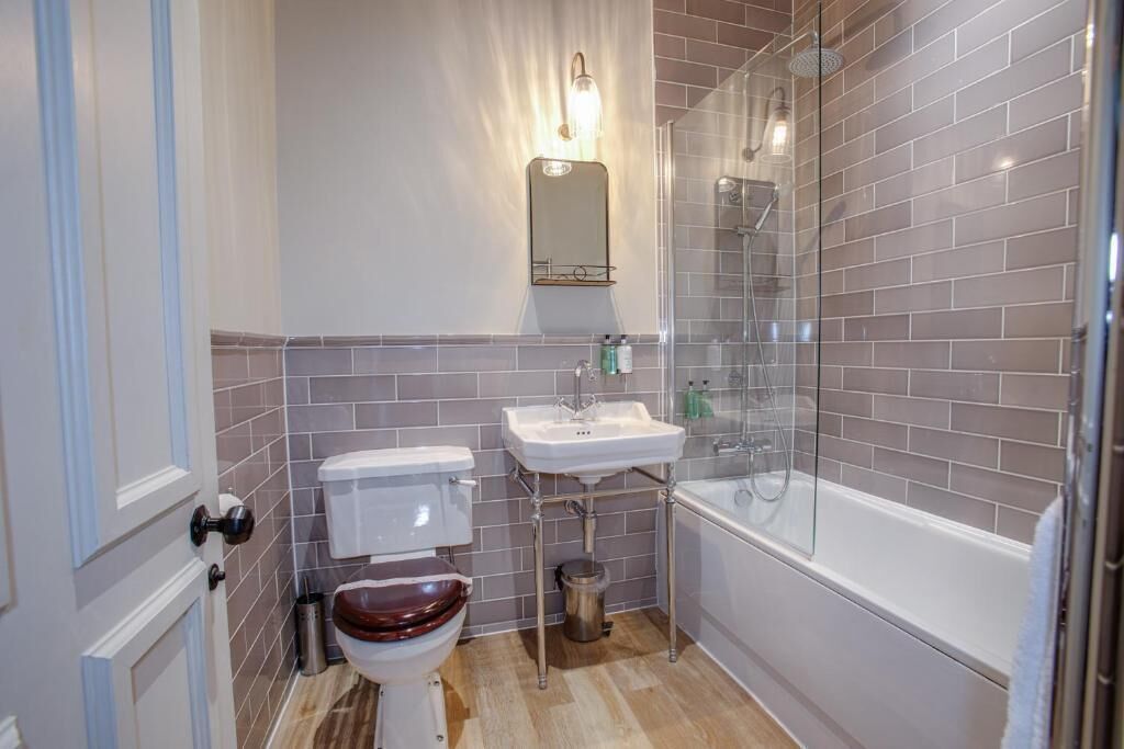 Une salle de bain avec des toilettes, un lavabo et une douche.