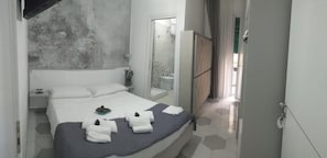 A hotel room with a bed, a nightstand, a mirror, and a wardrobe. - B&b Le due Costiere (Salerno)