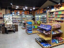 Un supermercado con varios pasillos repletos de productos como aperitivos, bebidas y artículos para el hogar.