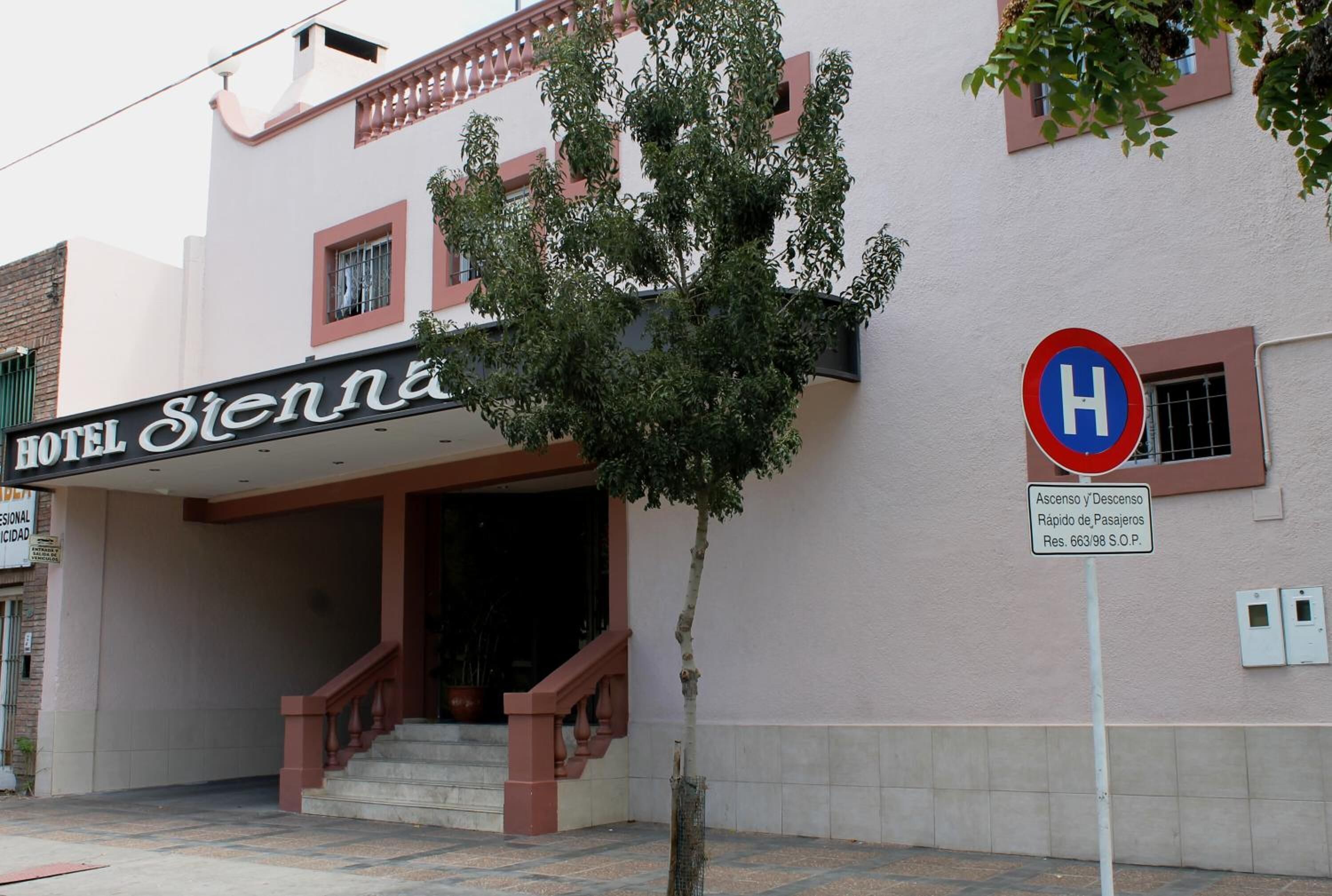 Entrada de un hotel con un cartel que dice "HOTEL Sienna".