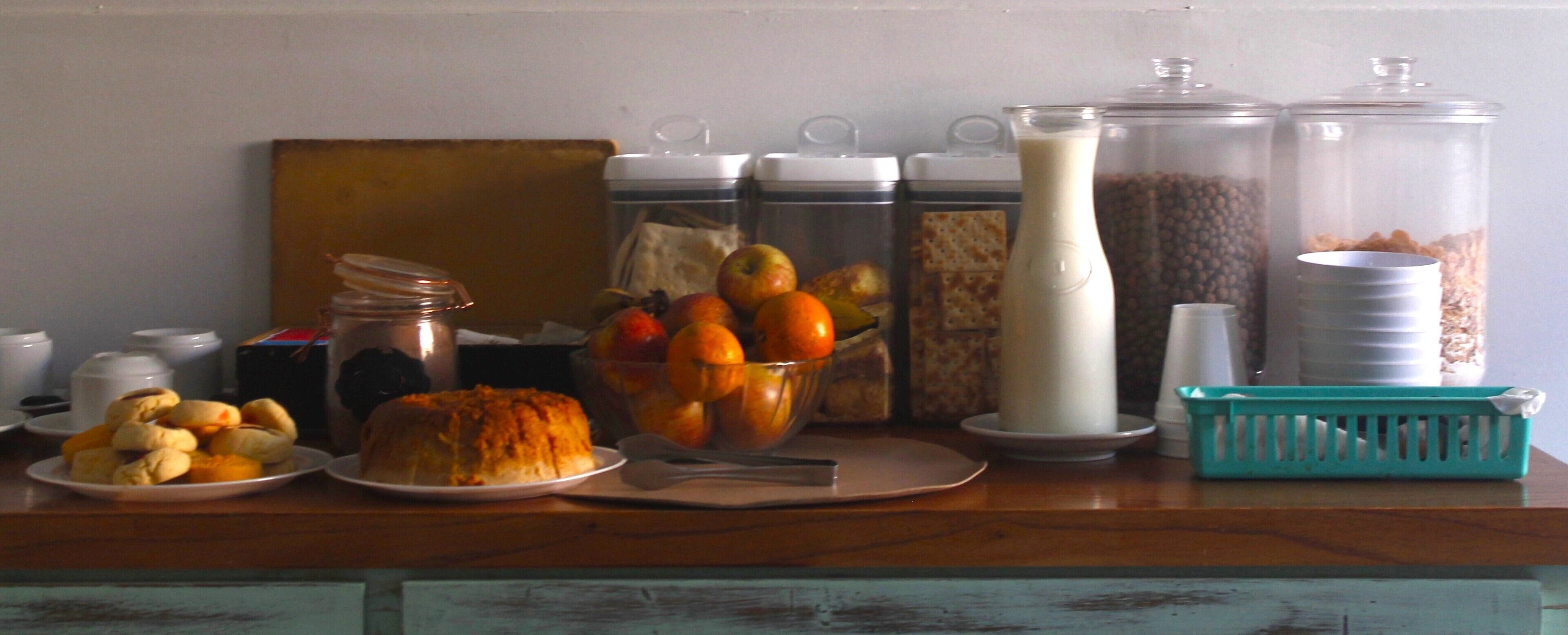 Buffet de café da manhã com diversos alimentos e recipientes.