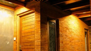 Une porte en bois avec un panneau de verre, un banc en bois et un tapis rouge sur un plancher en bois.