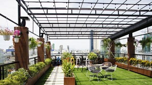 A rooftop terrace with artificial grass, potted plants, and outdoor furniture. - Anh Nguyet Hotel Da Nang (Da Nang)