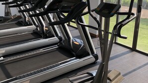 En rad löpband i ett gym med stora fönster som ger utsikt över omgivningarna.