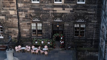 A historic building with a stone facade, multiple windows, and a central entrance.