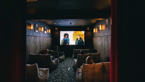 A theater with rows of leather seats, a large screen, and wall sconces. - CODE - The Court, Edinburgh (Edinburgh)