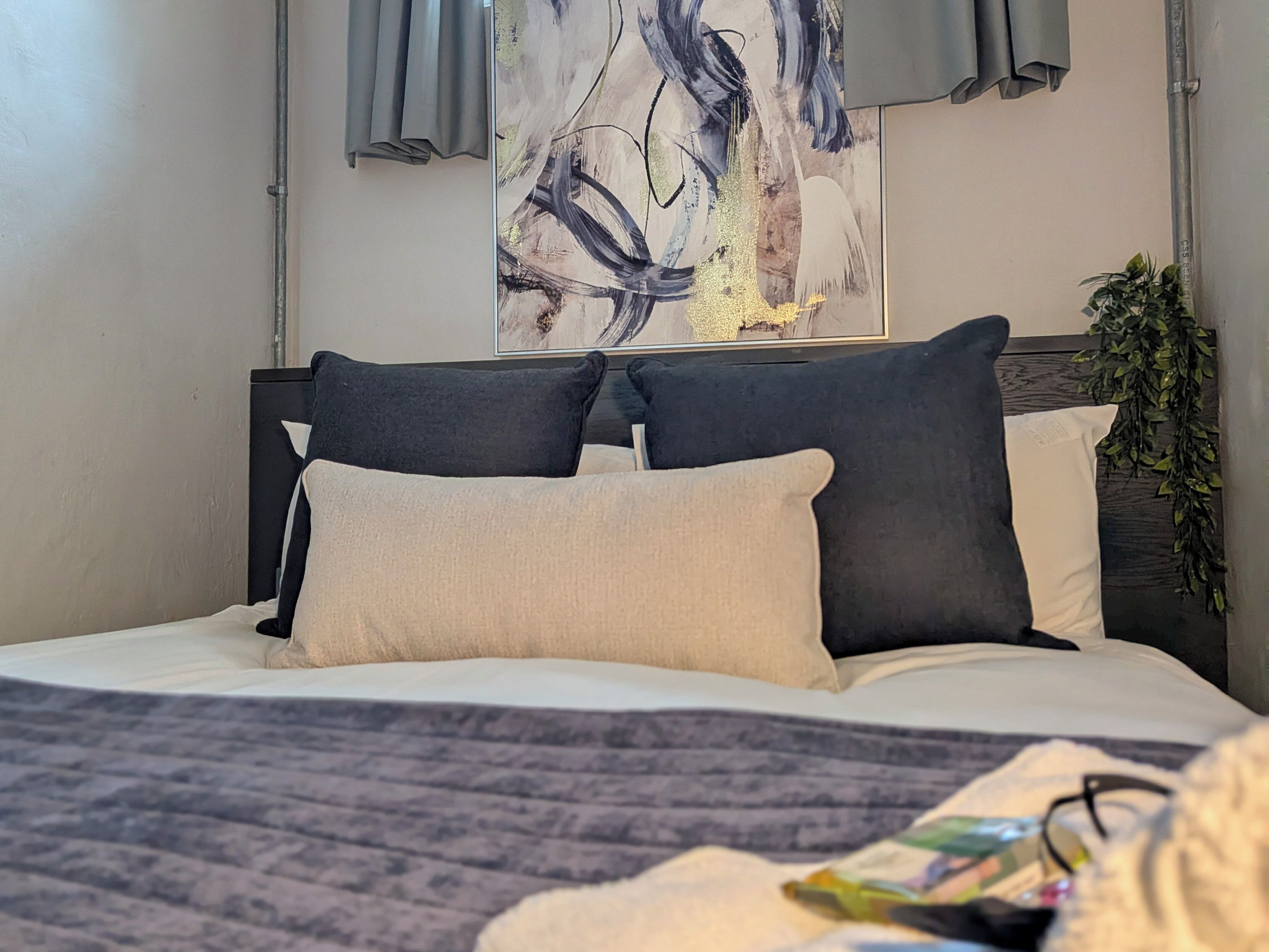 A bed with a headboard, pillows, and a blanket.