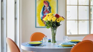 A dining table with plates, glasses, and a vase of flowers. - Fully remodeled home in the heart of Historic Santa Fe - AC - Easy stroll to All (Santa Fe)