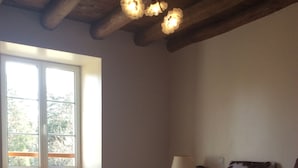 Un dormitorio con una cama, una ventana, una lámpara y un accesorio de iluminación en el techo.