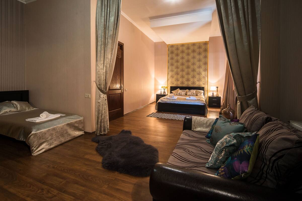A hotel room with a bed, a sofa, and a rug.