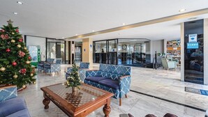 Eine großzügige Lobby mit Weihnachtsbaum, bequemen Sitzgelegenheiten und modernem Design.