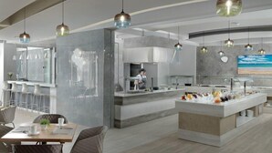 A modern kitchen with a central island, bar stools, and pendant lighting. - Bella Mare (Rethymno)