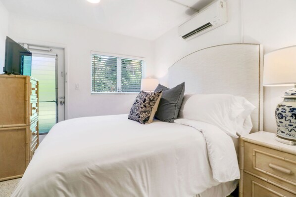 Une chambre à coucher comprenant un lit, une table de chevet, une lampe et un vase décoratif.