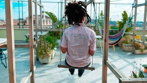 A person on a swing in an outdoor area with a hammock and potted plants. - Hotel Edera (Rome)