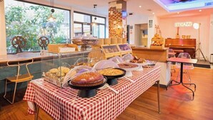 A buffet area with a checkered tablecloth, various food dishes, and a piano in the background. - Hotel Edera (Rome)