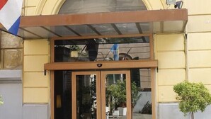 A hotel entrance with a double door, a small balcony, and a flag. - Hotel Edera (Rome)