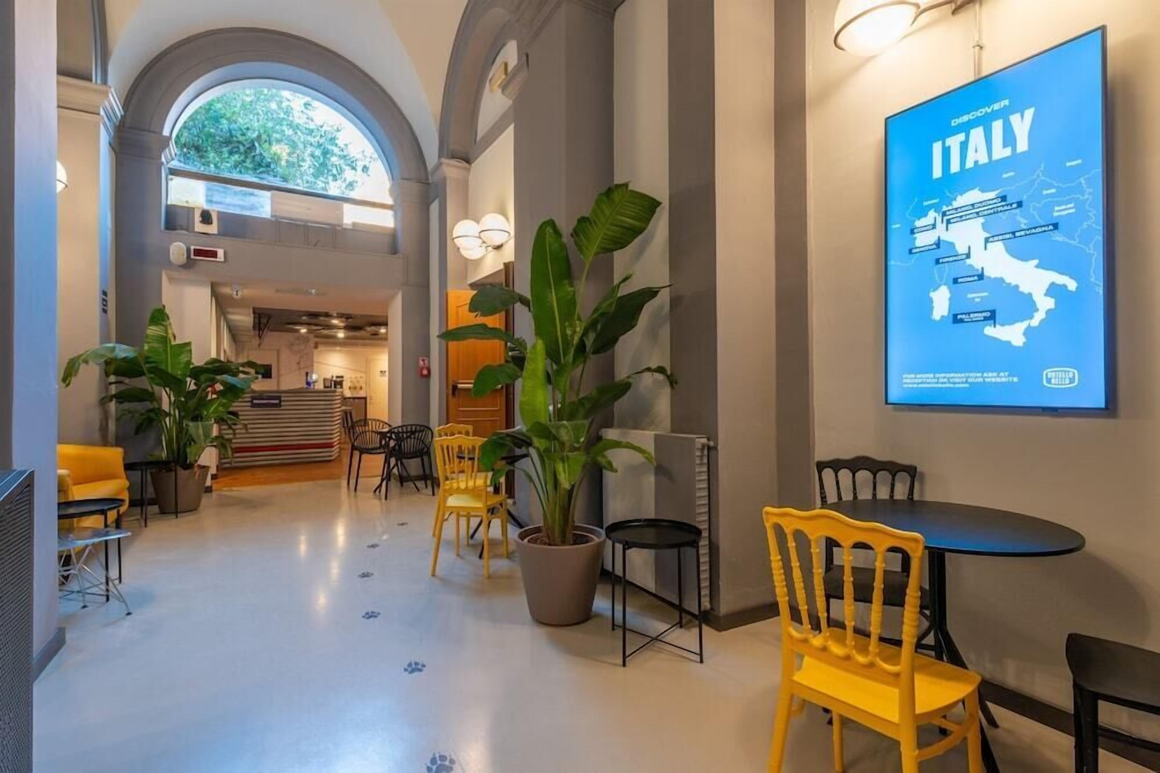 A spacious lobby with a large map of Italy, comfortable seating, and a modern design.