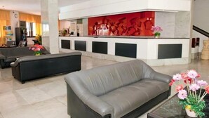 A modern lobby with a reception desk, sofas, and a decorative wall. - Koka Apartamentos (San Bartolomé de Tirajana)