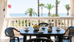 Una mesa preparada para el té, con vista al mar y palmeras.