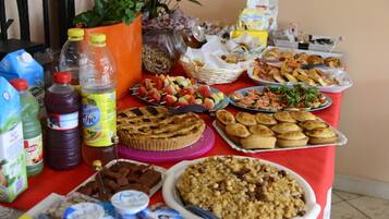 Una mesa con diferentes alimentos, como tarta, muffins y aperitivos.