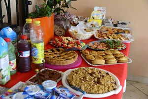 Una mesa con diferentes alimentos, como tarta, muffins y aperitivos.