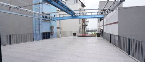 An industrial interior with a spacious, open floor plan, metal beams, and a blue conveyor system.