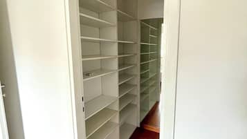 Corredor que leva a um armário com várias prateleiras.