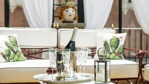 A table set with champagne glasses, a bottle, and a candle on a tray. - Relais 147 (Taormina)