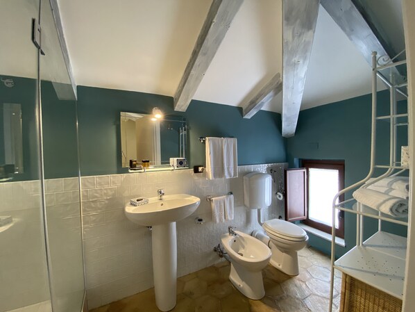 A bathroom with a sink, bidet, toilet, and a shower area. - Relais 147 (Taormina)