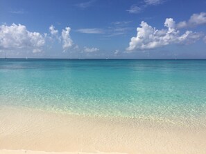 A beach with clear turquoise water and white sand.