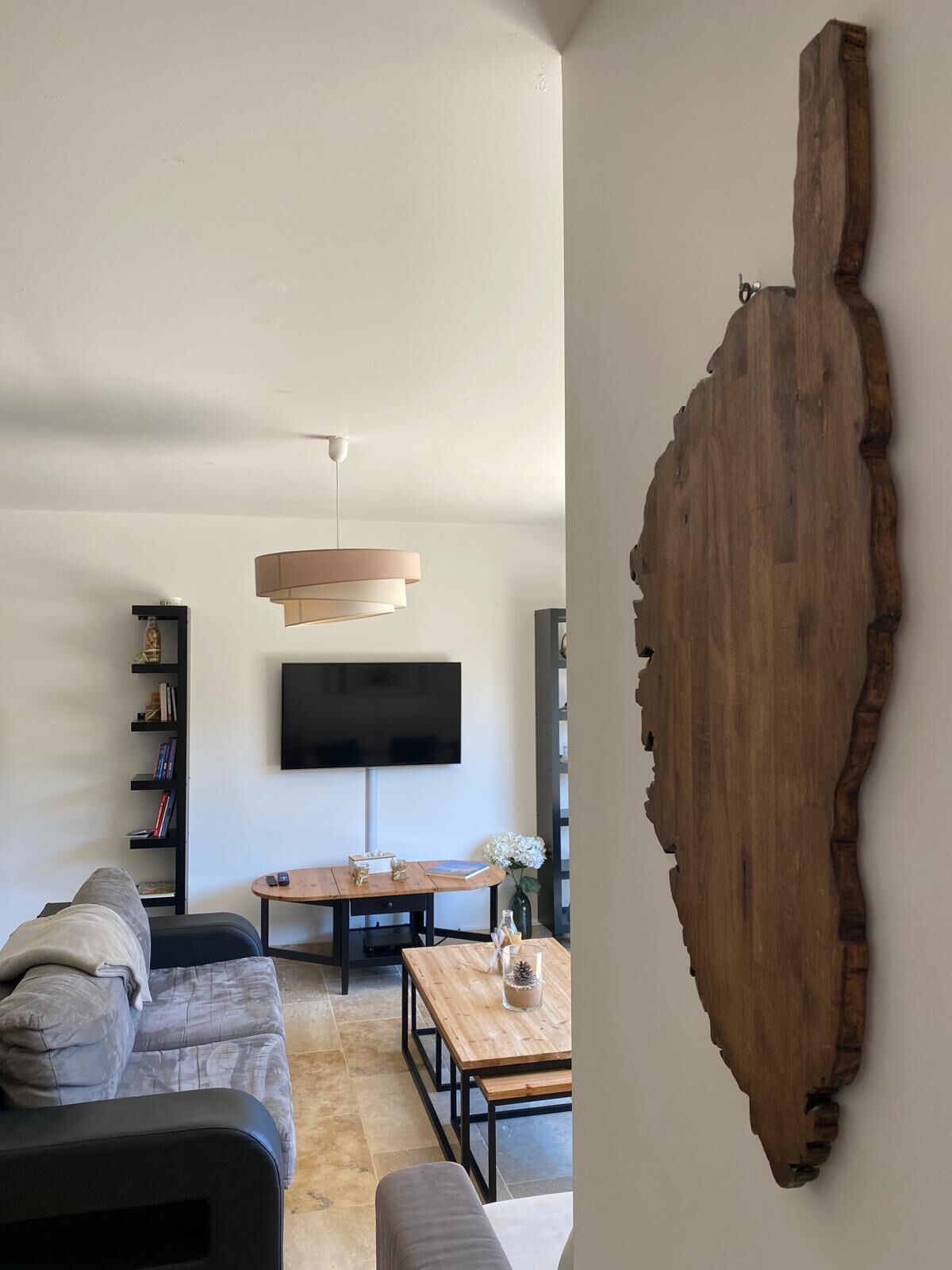 Un salon moderne avec un canapé, une table basse et un téléviseur.