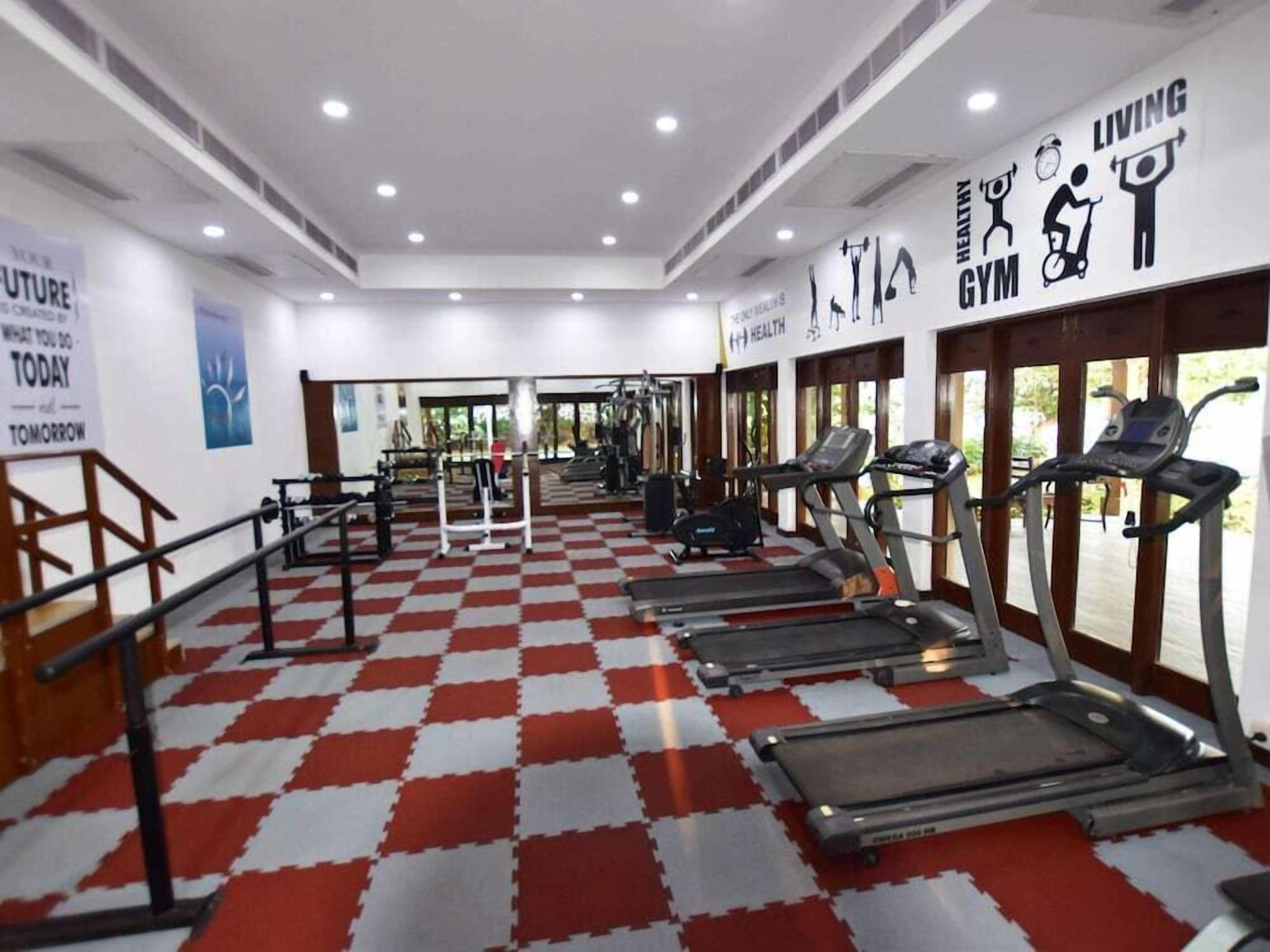 A gym with treadmills, exercise equipment, and motivational posters on the walls.