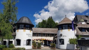Un edificio tradizionale con due torri, un ingresso centrale e un cartello che recita "Schloss Tavern".