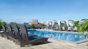 A poolside area with lounge chairs and a covered seating area. - Radisson Hotel Paramaribo (Paramaribo)