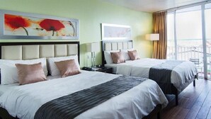 A hotel room with two beds, a large window with a view, and artwork on the walls. - Radisson Hotel Paramaribo (Paramaribo)