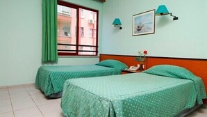 A room with two beds, a window with curtains, a painting on the wall, and two wall lamps. - Caprice Apartments (Alanya)