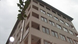 A multi-story building with a flat facade, numerous windows, and balconies. - Caprice Apartments (Alanya)