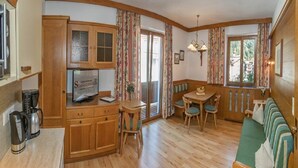 A cozy kitchen with wooden cabinets, a coffee maker, and a television. - Guesthouse Schneeberger (Zell am Ziller)