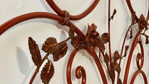 A wrought iron wall decoration with floral and scroll designs. - Residenza Sciarra (Rome)