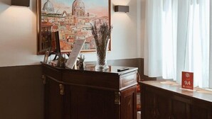 A reception desk with a painting of a cityscape, a vase with dried plants, and a sign indicating room number 94. - Residenza Sciarra (Rome)