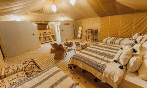 A tent with a bed, chairs, and a small table. - Dihya Desert Camp (Taouz)