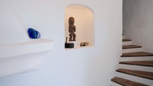 Un escalier avec une petite alcôve contenant une sculpture en bois et un bol.