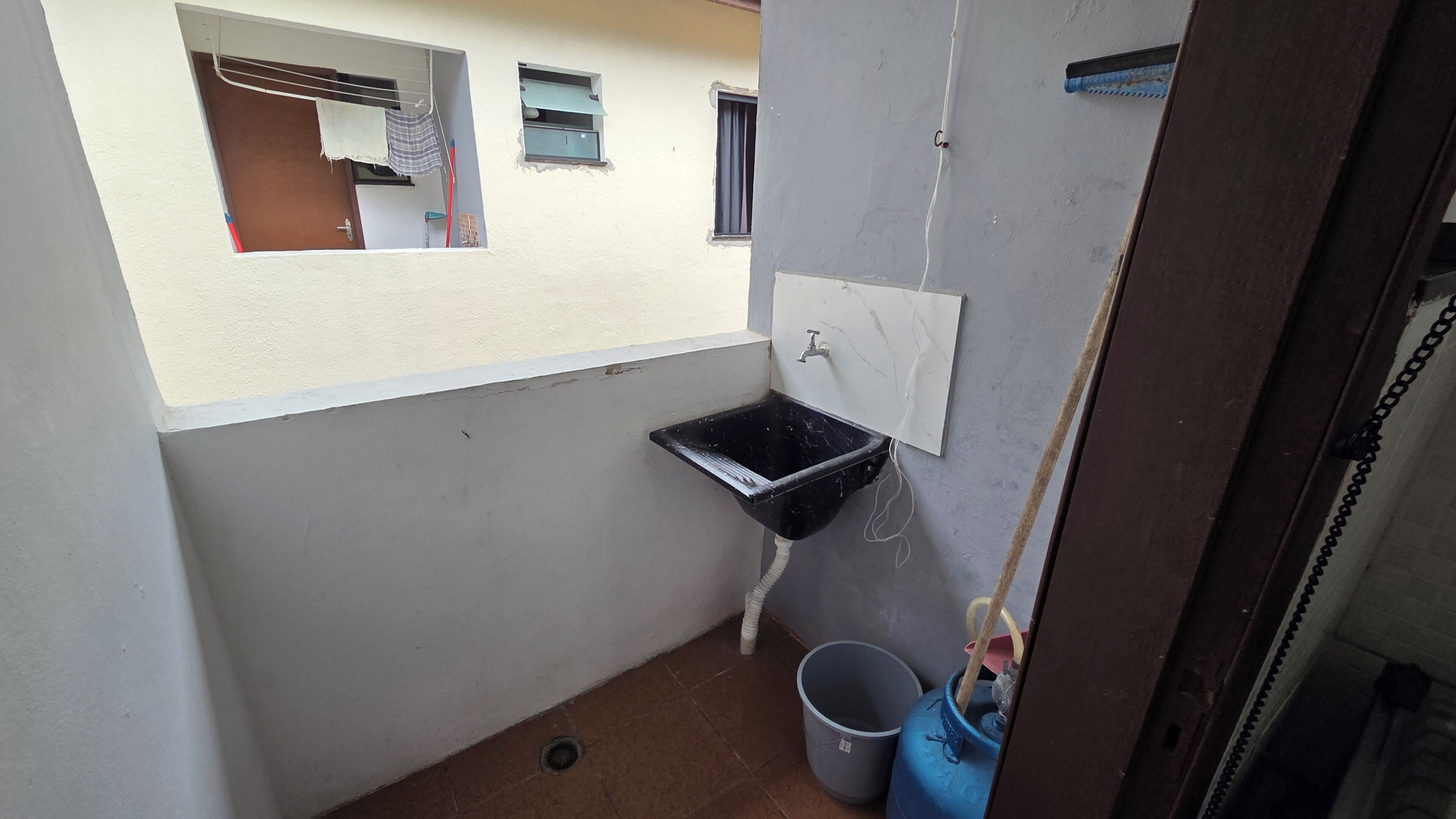A small bathroom with a black sink, a window, and a door.