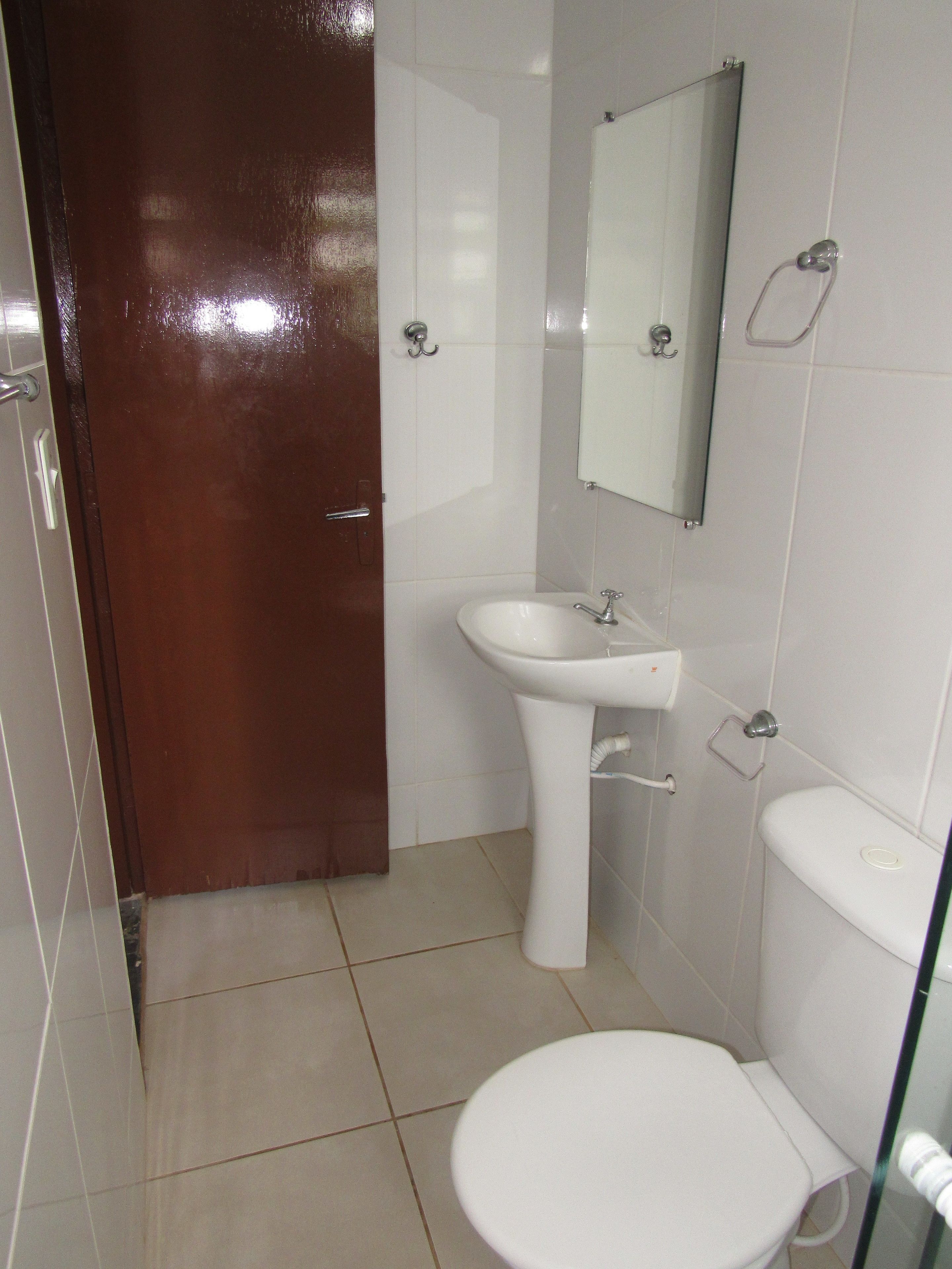 A bathroom with a white sink, a toilet, and a mirror.