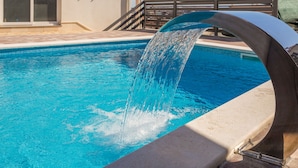 A swimming pool with a water feature.